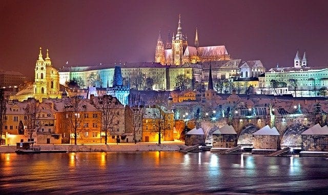 Vista nocturna de Praga con el puente San Carlos a la derecha